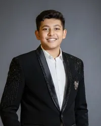 Safal Mutha in a black suit, smiling
